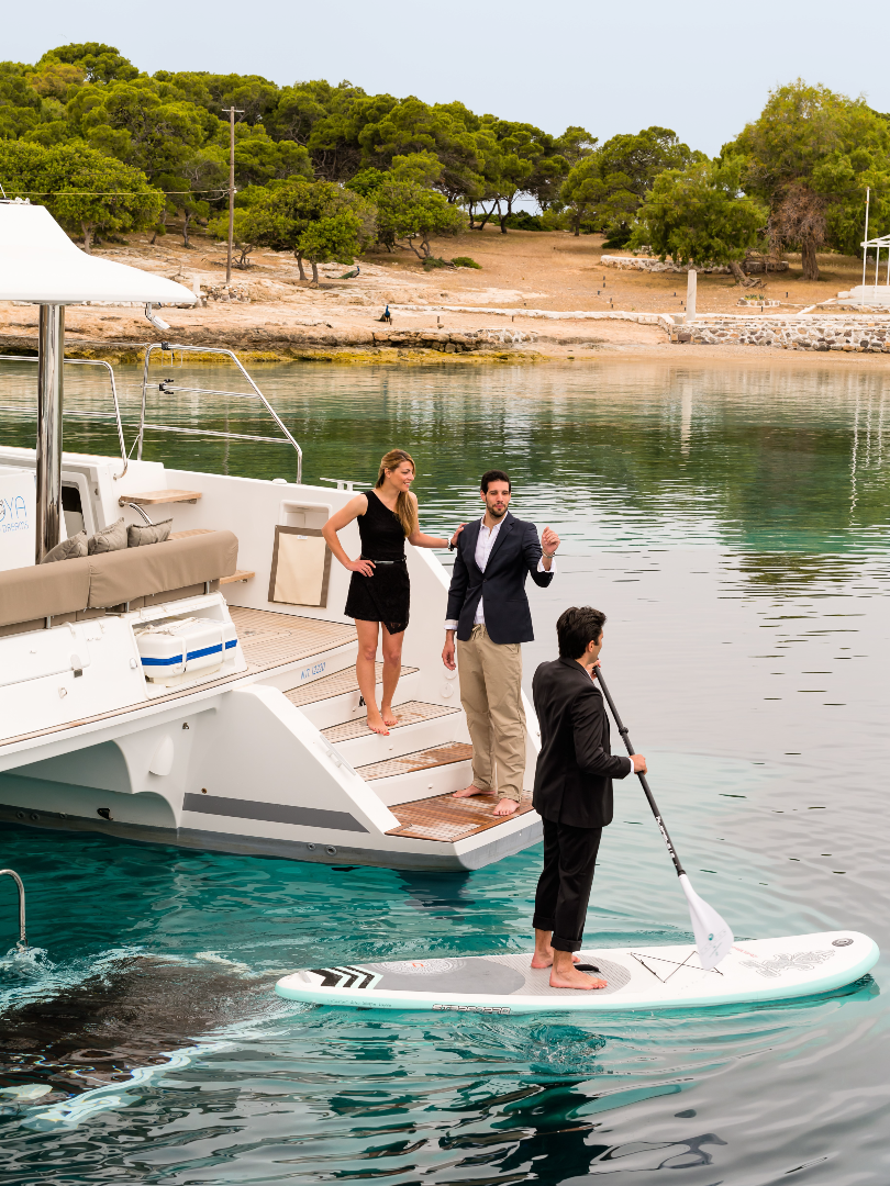 catamaran-couple-on-passage-a-man-on-paddle-board