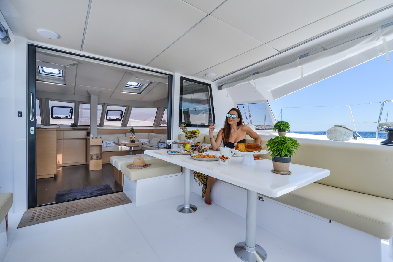 catamaran-girl sitting-on-deck-eating-lunch