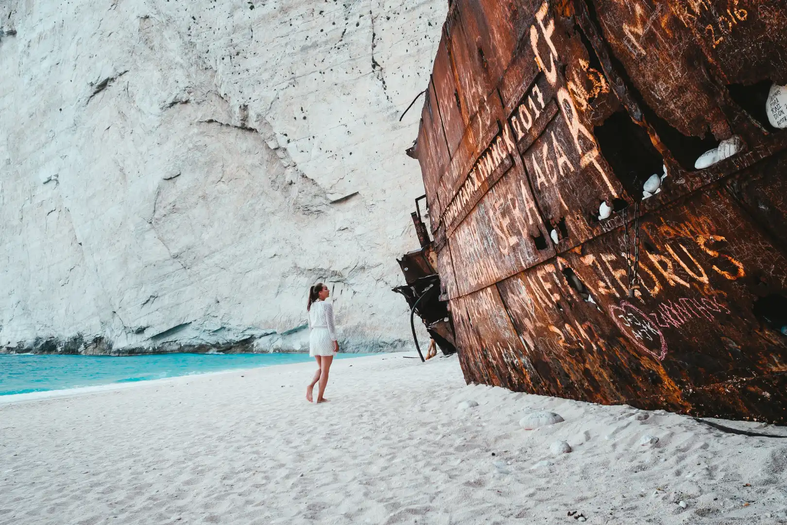 Girl-looking-ship-wreck-on-Zakynthos-beach