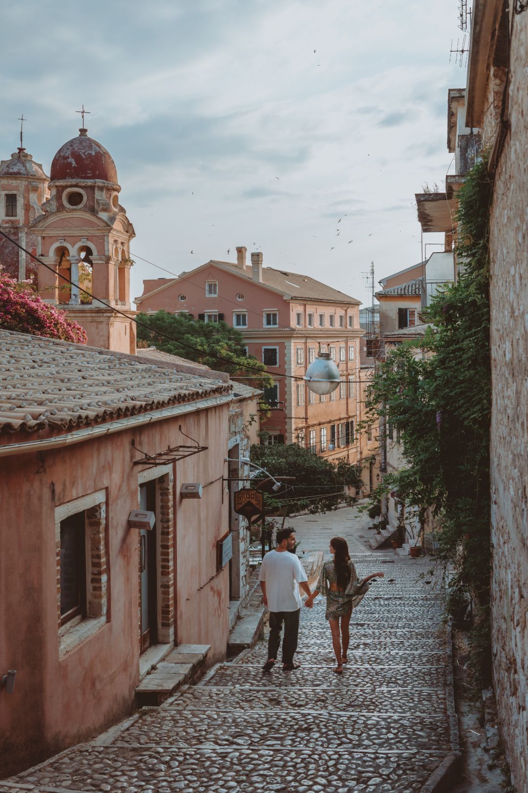 couple-walking-down-street-corfu